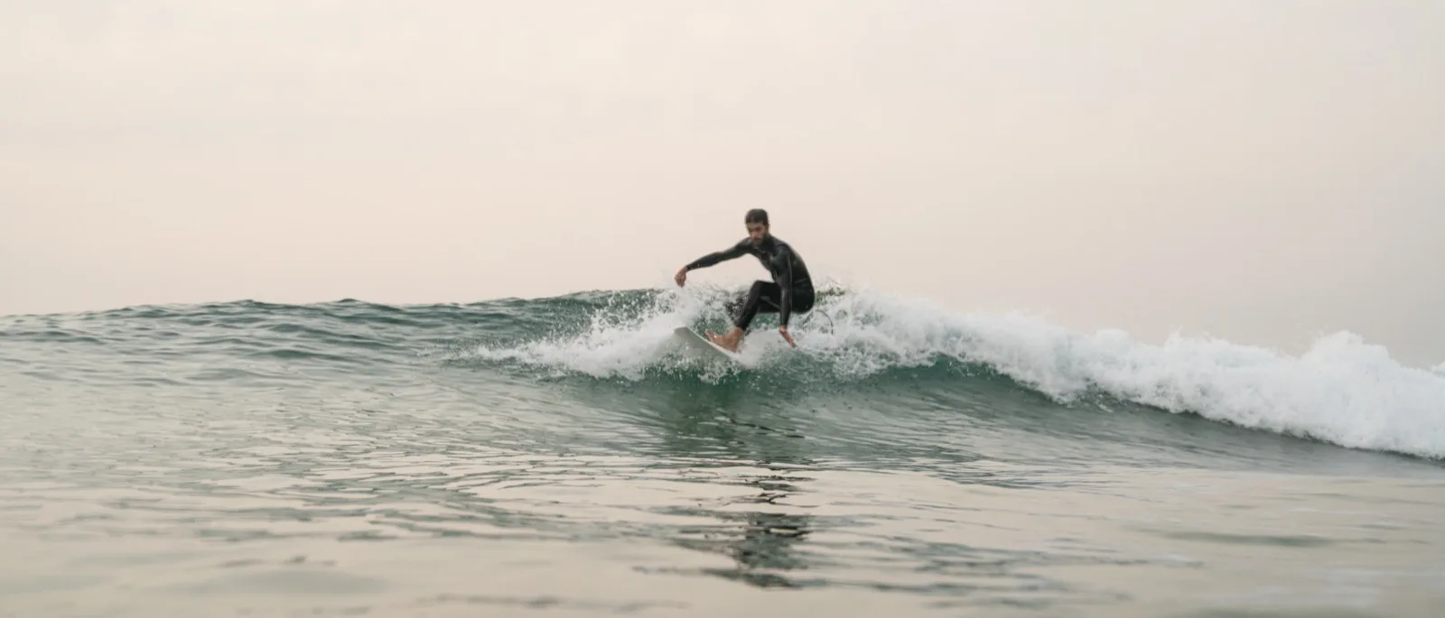 Surfer mid bottom-turn on a clean wave, intermediate progression concept